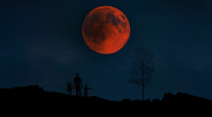 A family in silhouette watching the 2018 Lunar Eclipse 